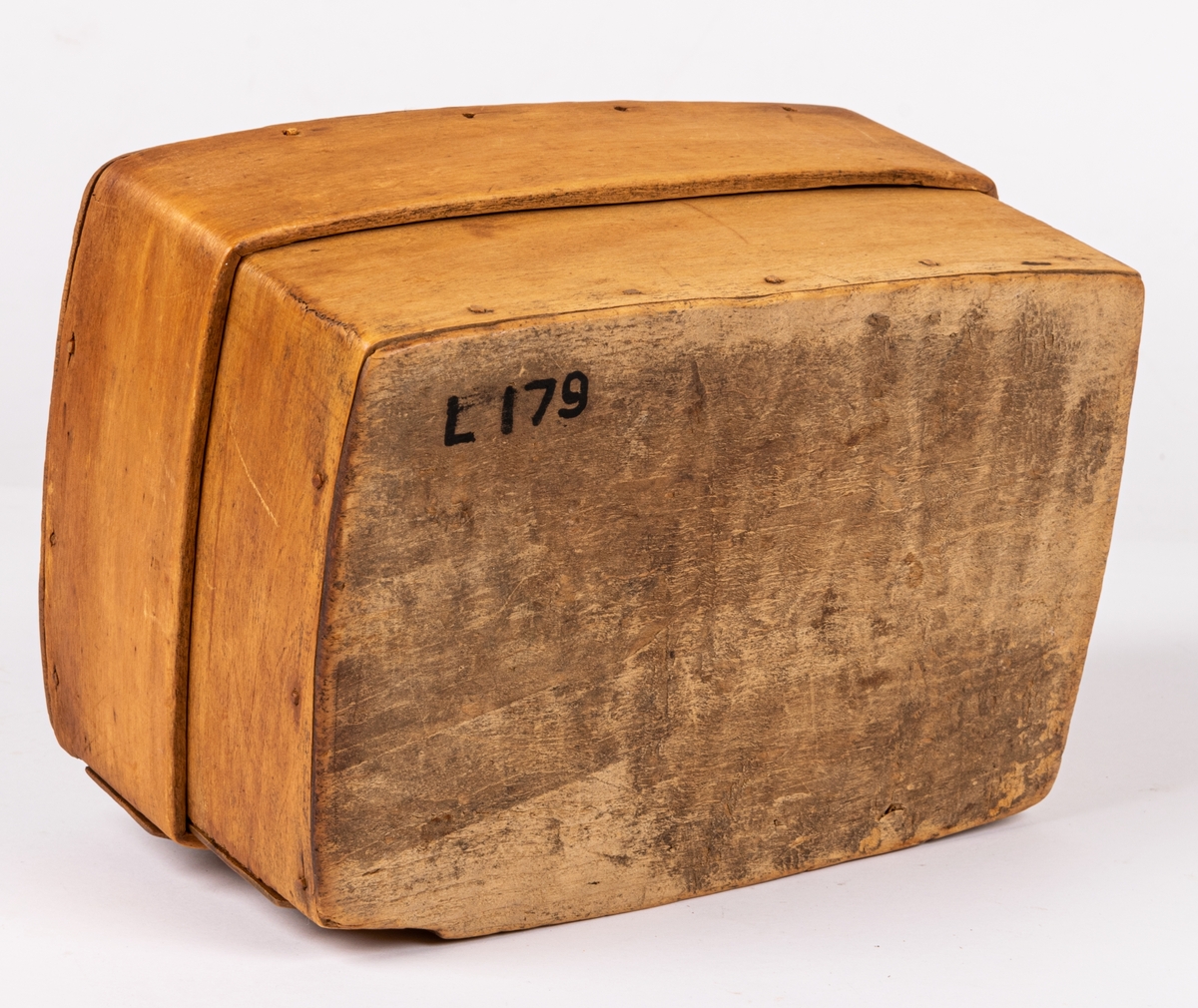 Ask med trycklock, fyrsidig, av trä, utskuret på en sida samt på locket: "LARS PDS GJORD WID DRÅNINGHÅLM 21 OW 1779". Svepteknik. På ena sidan av lådan och på dess lock är övre skiktet av svepet genombrutet av utskurna fyrarmade figurer med rött resp. vitt papper under.