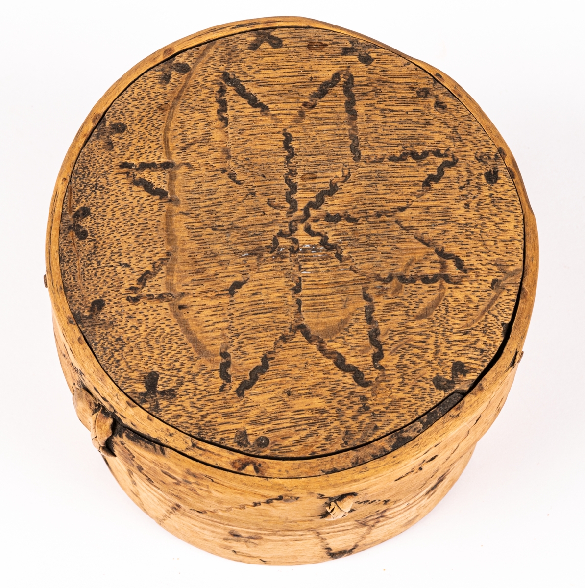 Ask, ornerad genom brännstämpling. I botten märkt 1783.
I svepteknik, rund med lock. Botten och lock av ek. Ornament: fyrbladiga rosor samt krusiga linjer.