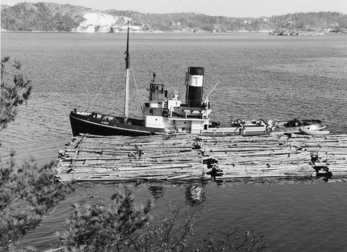 Isbryteren "Bjønn" har tauet tømmer inn til Kirkebukta, Kragerø.
Stilnestangen i bakgrunn og Ytre Strandvei i forgrunn.