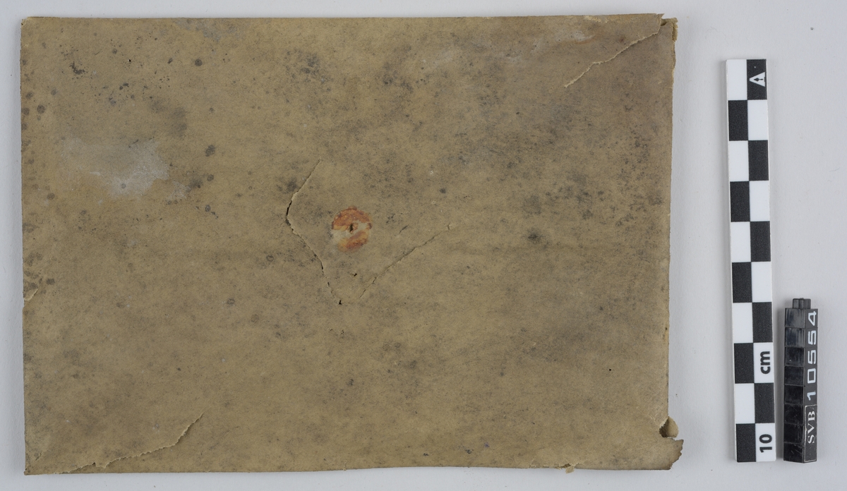 Kasse av tre. Bunnen og toppen er heldekkene, mens sidene er laget av langsgående trebord med mellomrom, avstivet med kortere bord på tvers i bunn og på midten. På innsiden av trebordene er det montert netting. Inni kassen er det montert et kortbølgeradiorør av glass og metall. Røret er suspendert i midten av kassen ved hjelp av to tekstilbiter, én i hver ende. Disse er holdt på plass av åtte metallfjærer, fire i hver ende, som er montert i kassens hjørner. Fjærene er montert ca. midt på kassens øverst halvdel og midt på kassens nederste halvdel. På den ene siden av kassens bunn er det montert to 90-graders metallbraketter. Langs toppen av den ene siden av kassen er det montert en lengre metallbrakett. I toppen av kassen er det festet tau og en papirlapp. På kassens utside er det trykket svart tekst. Trebordene holdes sammen med spiker og stifter av metall.