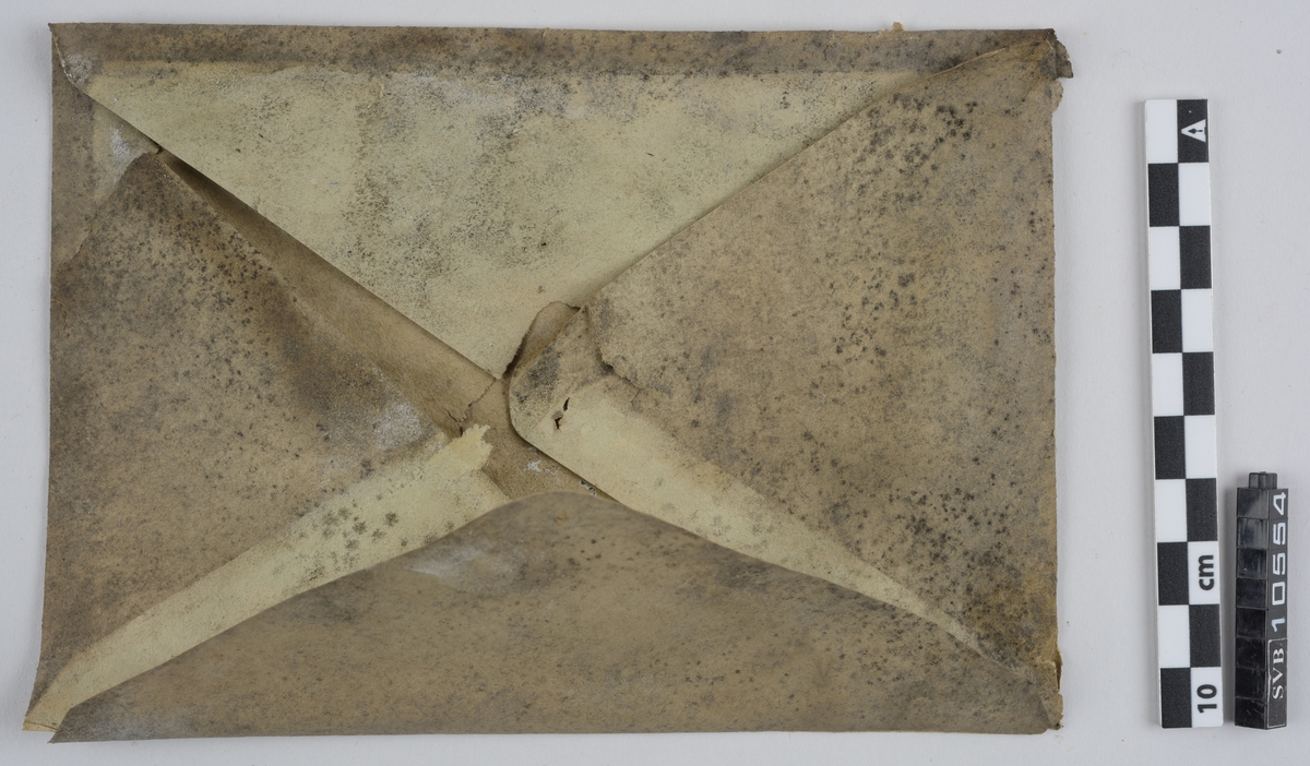 Kasse av tre. Bunnen og toppen er heldekkene, mens sidene er laget av langsgående trebord med mellomrom, avstivet med kortere bord på tvers i bunn og på midten. På innsiden av trebordene er det montert netting. Inni kassen er det montert et kortbølgeradiorør av glass og metall. Røret er suspendert i midten av kassen ved hjelp av to tekstilbiter, én i hver ende. Disse er holdt på plass av åtte metallfjærer, fire i hver ende, som er montert i kassens hjørner. Fjærene er montert ca. midt på kassens øverst halvdel og midt på kassens nederste halvdel. På den ene siden av kassens bunn er det montert to 90-graders metallbraketter. Langs toppen av den ene siden av kassen er det montert en lengre metallbrakett. I toppen av kassen er det festet tau og en papirlapp. På kassens utside er det trykket svart tekst. Trebordene holdes sammen med spiker og stifter av metall.