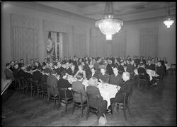 Män och kvinnor sitter runt långbord och firar Alingsås gymn