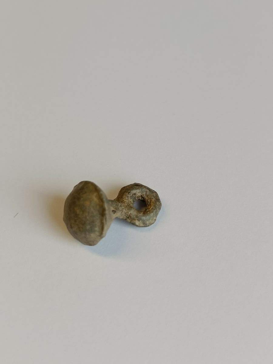 Halvkuleformet overside, konisk underside med tydelige støpekanter. Stilk og øye også med tydelige støpekanter.