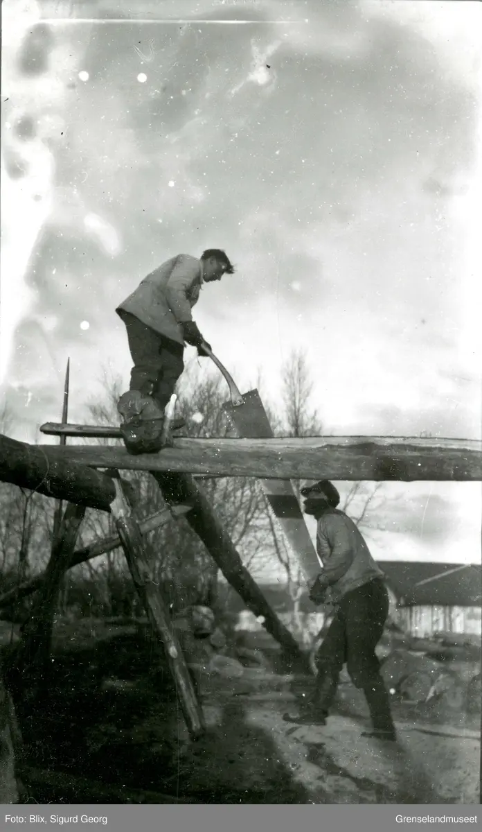 To menn sager en stokk med stokksag.  