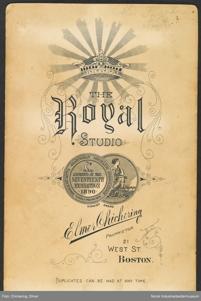 Visittkortfoto, kvinne fotografert i studio. Kvinnen er kledd i kjole med kosettliv, halvfingerhansker og hatt på hodet. Hun holder en paraply i den ene hånden og en lommebok i den andre. Bak henne står det en stol på høyre side og en gardin på venstre side.