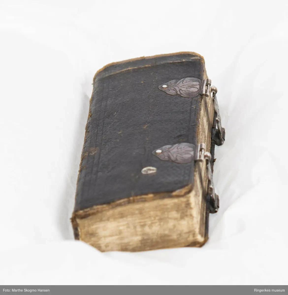 Liten salmebok. 270 sider. Trykket i København i 1762. Uleselig håndskrift på de første og siste sidene. Trepermer trukket med lær på utsidene. Boken lukkes med mønsterdekorerte tinnlåser. Sidenes utsider har innskåret mønster.