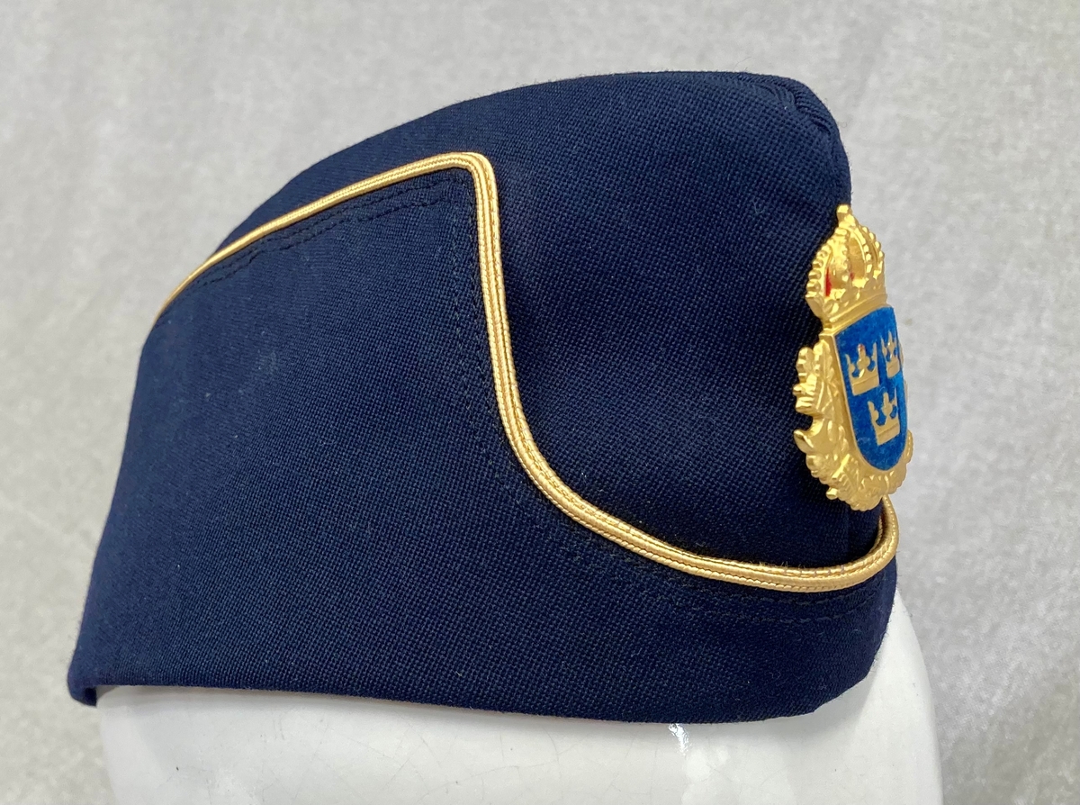 Uniformslue for svensk politi. Mørkeblå båtlue med gulldetaljer og svensk politimerking.