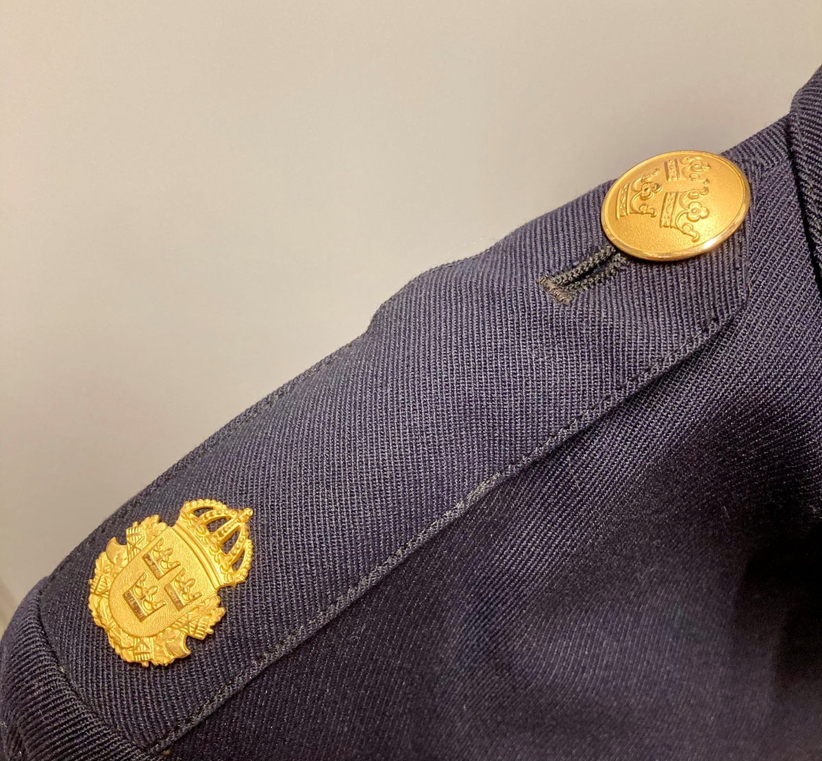 Uniformsjakke for svensk politi. Mørkeblå med gullfargede metallknapper.