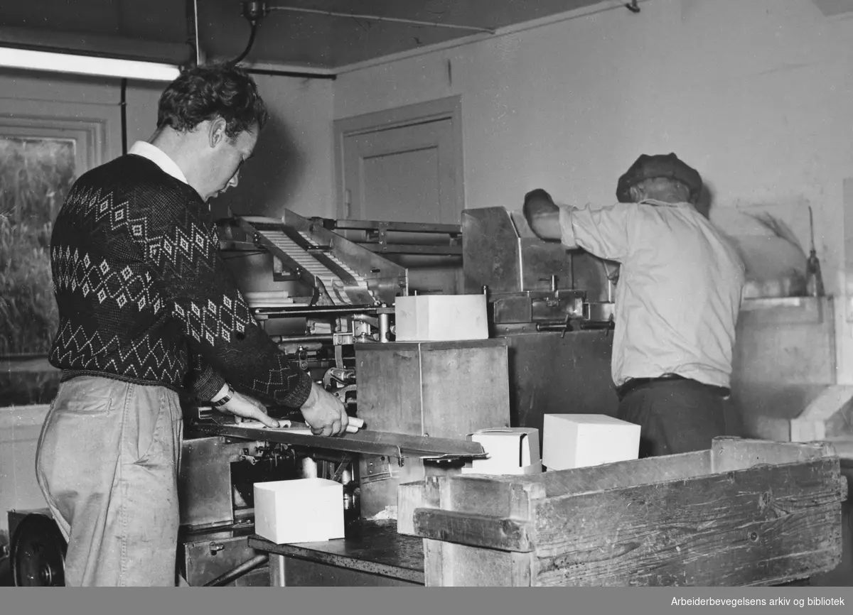 "En norsk industribedrift". En av patroneringsmaskinene. Den passes av Harry Kristiansen og Hans Jensen. Billedreportasje fra Grubernes Sprængstoffabrik i Magasinet for Alle, desember 1954.