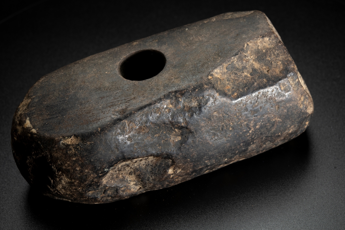 Skafthålsyxa av bergart.