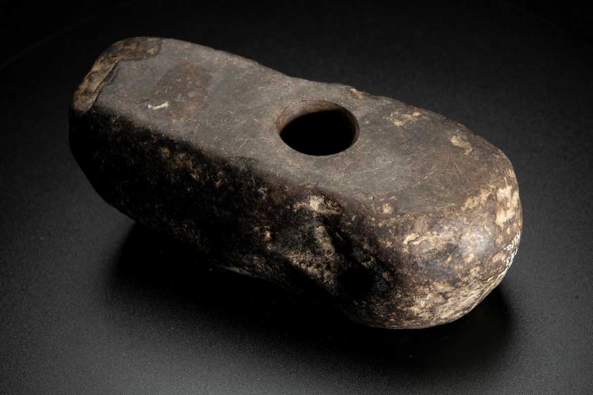 Skafthålsyxa av bergart.