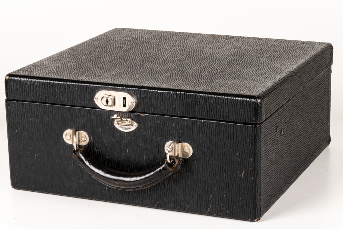 Reseskrivmaskin, Underwood Portable. Svartlackerad plåt. Runda tangenter med text på vit botten under cellulloid och med förnicklade kanter. Text: "UNDERWOOD" resp "UNDERWOOD PORTABLE" i guldfärg samt "A-B HADAR SCHMIDT GENERALAGENT STOCKHOLM". Tillv.nr: 659847.
I svart låsbar låda med bärhandtag. Nyckel saknas.