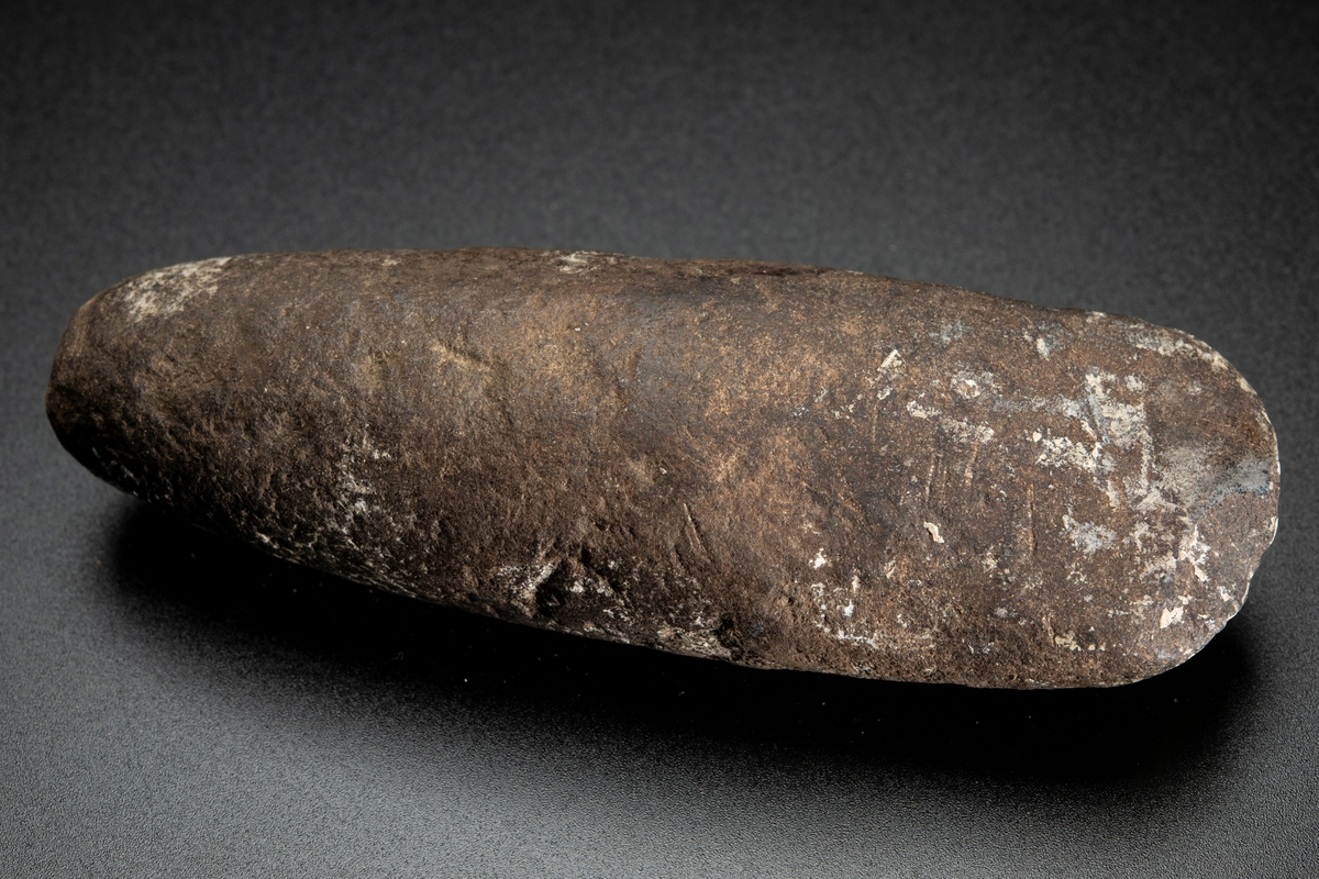 Ovalt (i det närmaste runt) tvärsnitt. Eggen sliten. Delvis slipad.