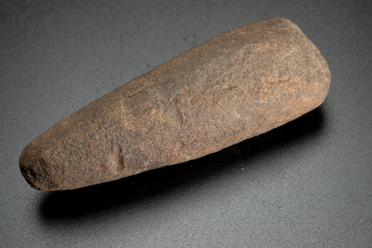 Tvärsnittet ovalt mot eggen, runt mot nacken. Vittrad.