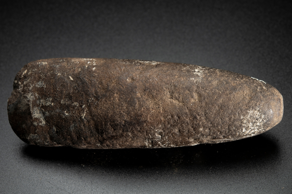 Ovalt (i det närmaste runt) tvärsnitt. Eggen sliten. Delvis slipad.