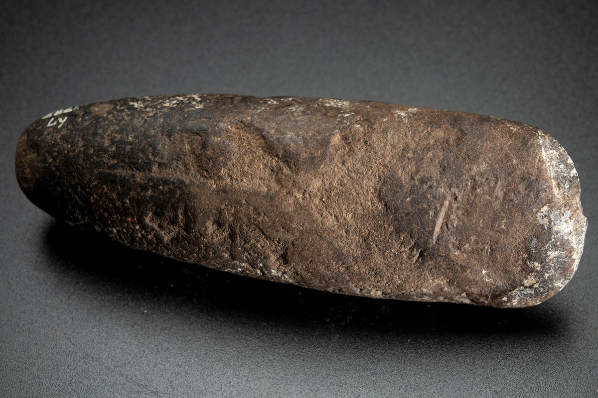 Ovalt (i det närmaste runt) tvärsnitt. Eggen sliten. Delvis slipad.