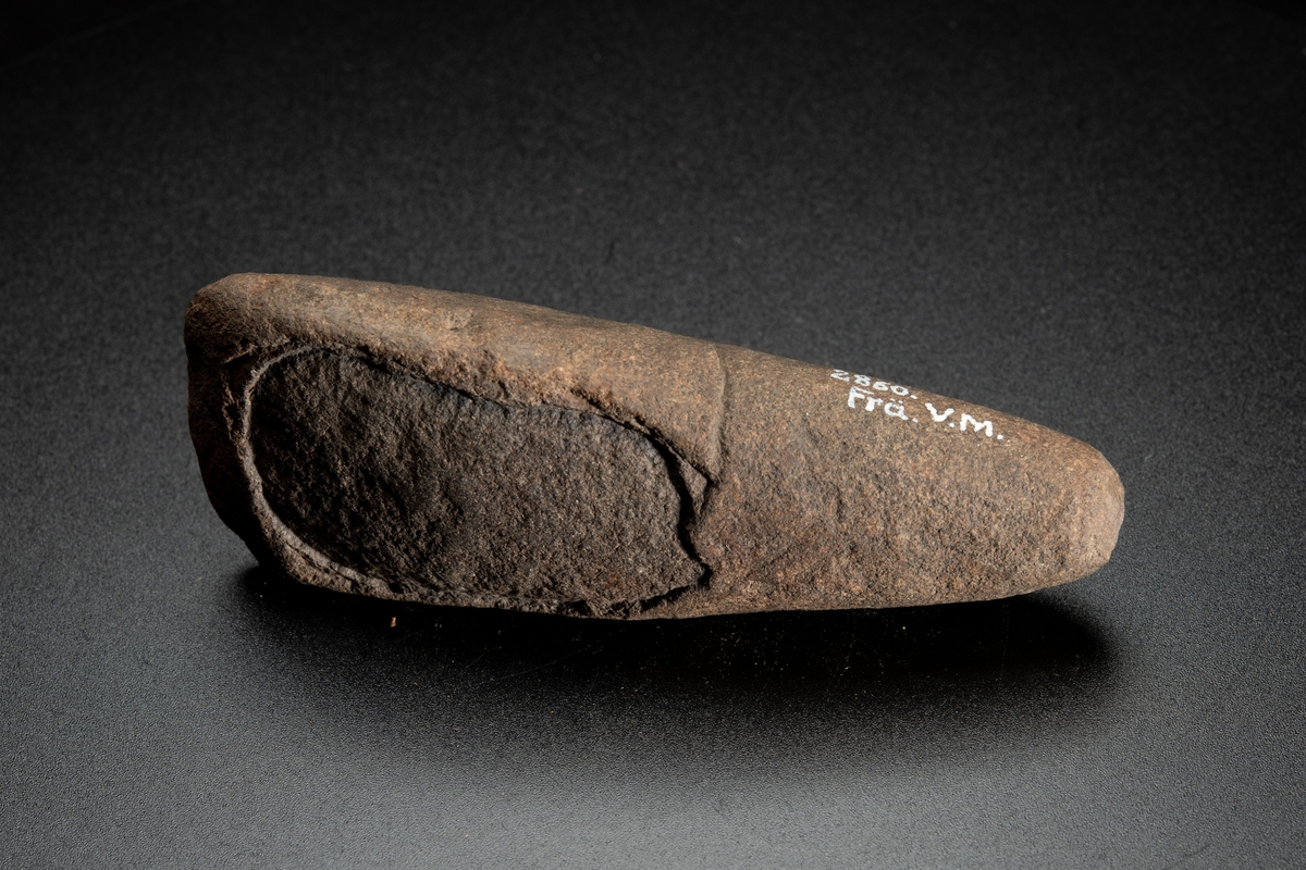 Tvärsnittet ovalt mot eggen, runt mot nacken. Vittrad.