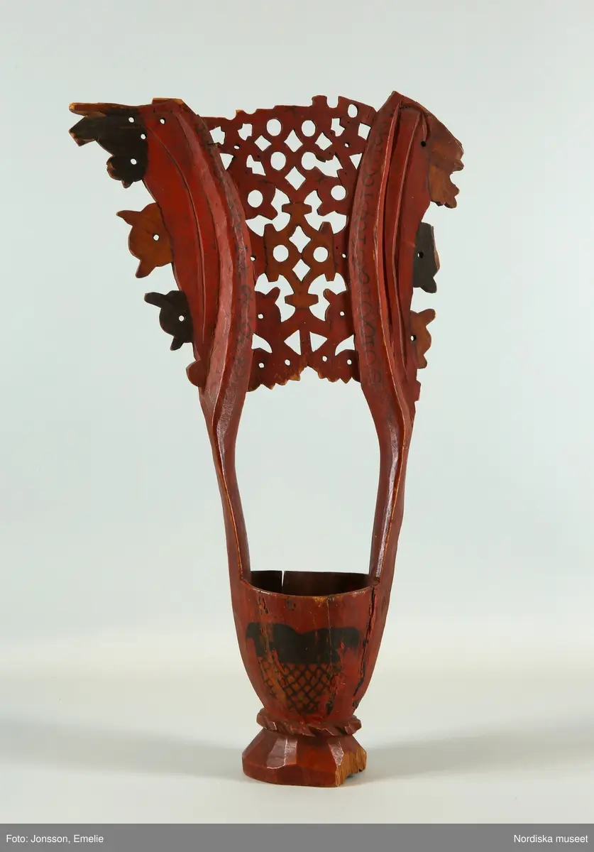 Katalogkort:
Kåsa av gran, rödmålad, omkr. 1590 (Cleve). Med Bielkes och Stures vapen (Hogenskild Bielke och Anna Sture, gifta 1569). Med ornament i svart färg."