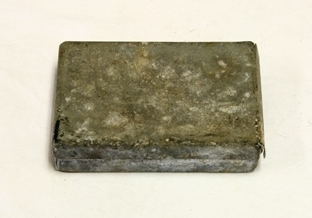 Eske m/skobesparelser. Rektangulær. Sink. Slitt. Overdel trees over underdel. Inne i esken er ei tilpasset eske av papp. Klaffeåpning i ene kortenden. Skrift. Inneholder skobesparelser.