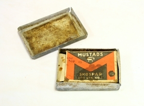 Eske m/skobesparelser. Rektangulær. Sink. Slitt. Overdel trees over underdel. Inne i esken er ei tilpasset eske av papp. Klaffeåpning i ene kortenden. Skrift. Inneholder skobesparelser.