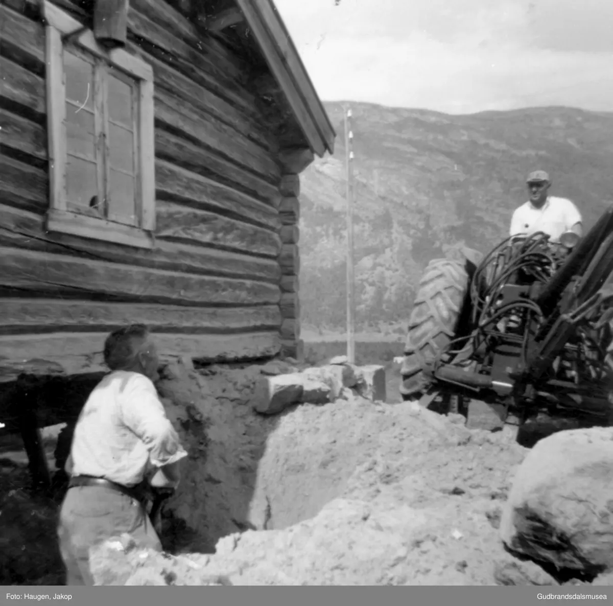 Kristen Jonsgard, Flathaugen (f. 1918) med traktorgravar. Sigurd Haugen, Jonsgard (f. 1896) er hjelpemann ved utgraving av møkkakjellar under fjøset på søre Haugen