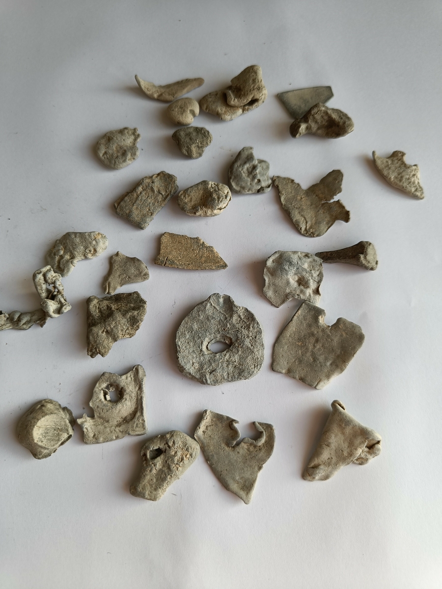 Ulike plater og smelteklumper fra metallhåndverk der man har støpt i bly i verkstedene.