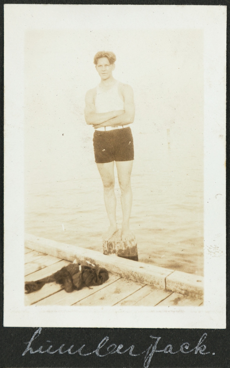 En ung mann står på på ei påle ved en brygge på Calvary beach.