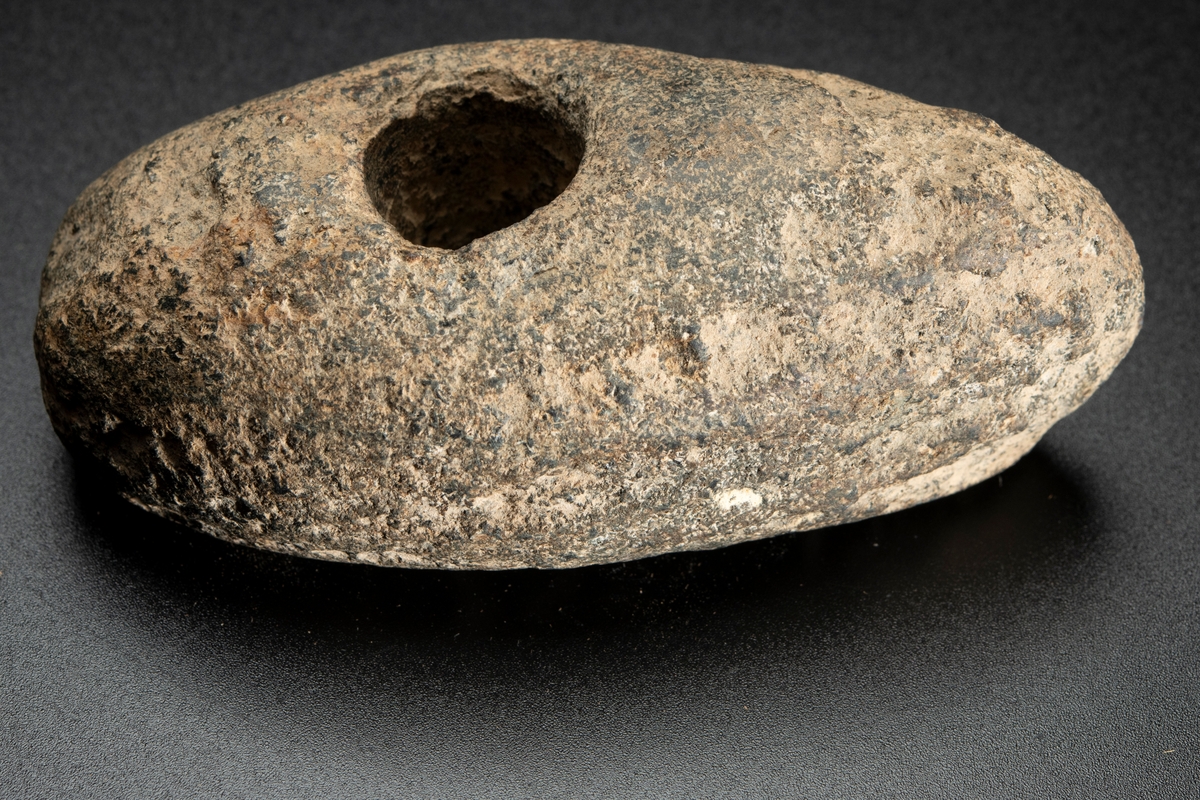 Vittrad, ursprungligen slipad över hela ytan. Plan undersida, välvd ovansida.