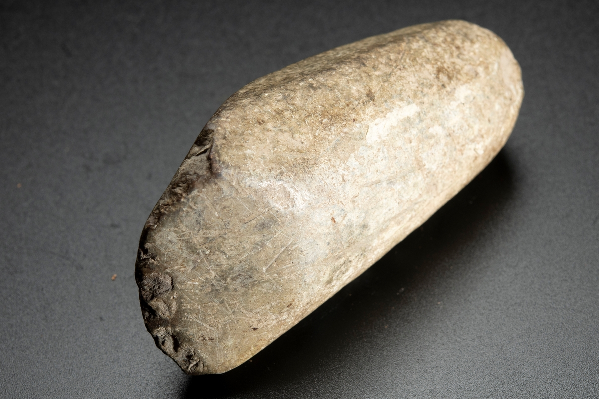 Baneparti av större yxa. Omslagen och omslipad för eggbildning. Starkt välvda bredsidor. Rund i nacken.