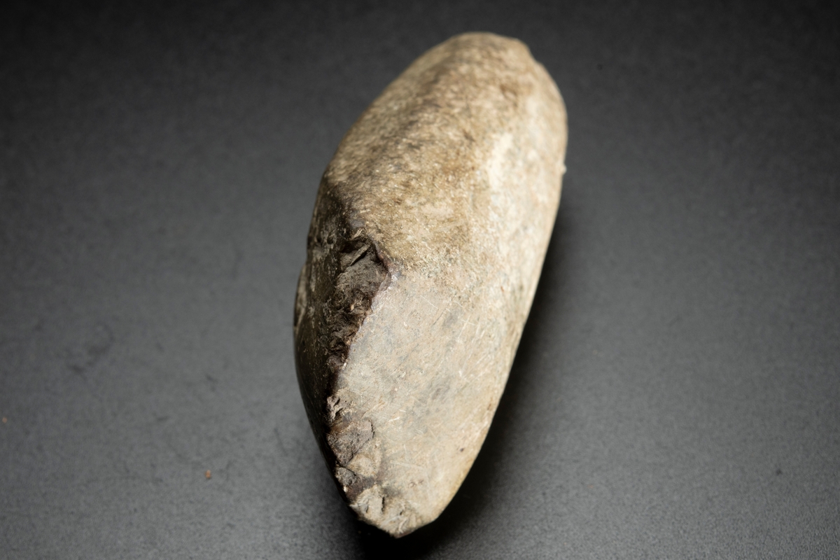 Baneparti av större yxa. Omslagen och omslipad för eggbildning. Starkt välvda bredsidor. Rund i nacken.