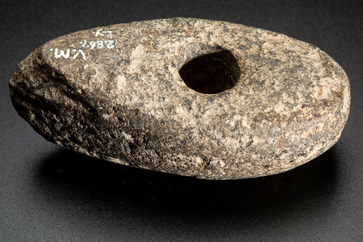 Vittrad, ursprungligen slipad över hela ytan. Plan undersida, välvd ovansida.