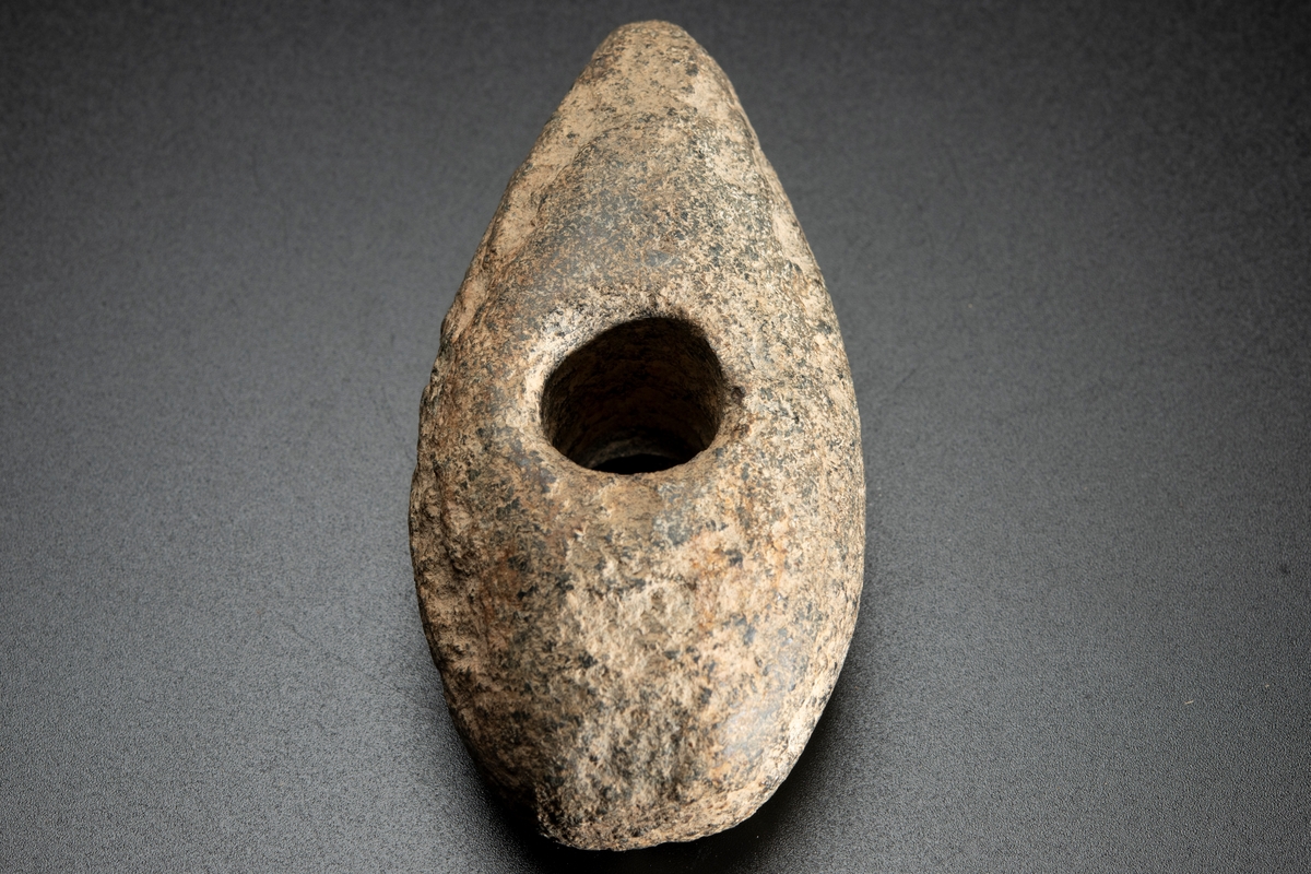 Vittrad, ursprungligen slipad över hela ytan. Plan undersida, välvd ovansida.