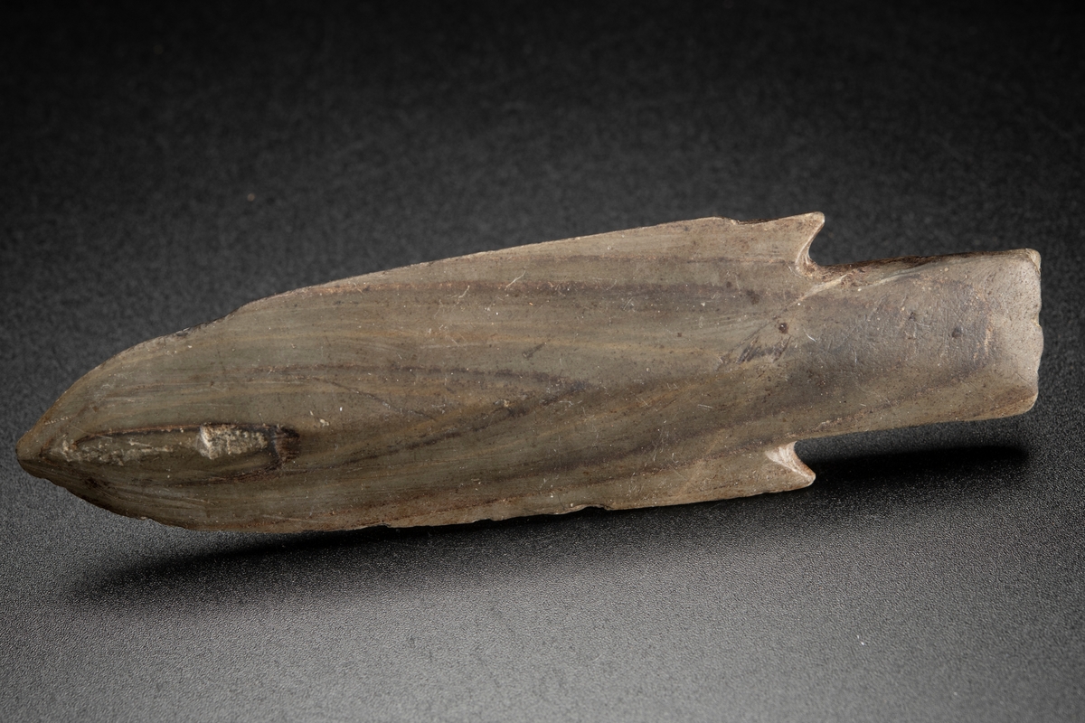 Av den breda typen, med hullingar och kraftig tånge. Vackert vinkelbandsmönster i skiffern.