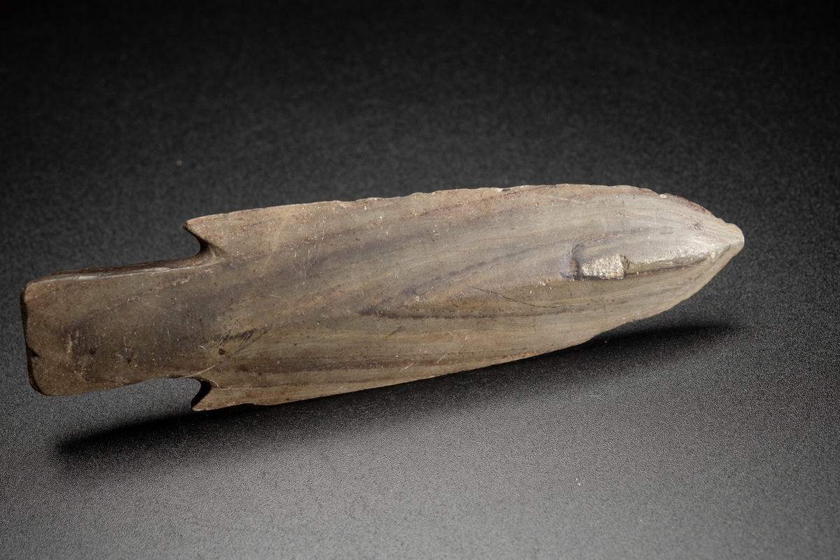 Av den breda typen, med hullingar och kraftig tånge. Vackert vinkelbandsmönster i skiffern.