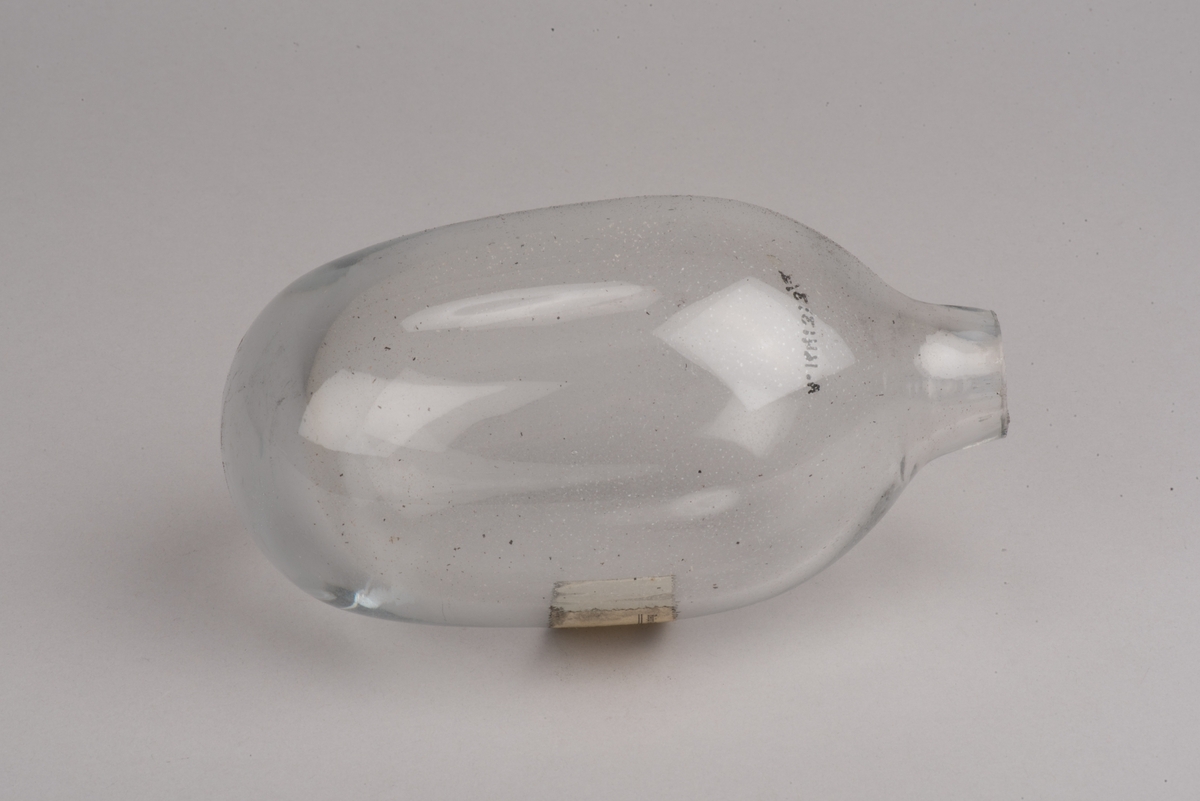 Påbörjad blåst glaskanna med träform.

Delbar form av trä som hålls ihop av märlor. På insidan utkarvad form för kanna. På utsidan två borrade hål, som inte är helt genomborrade, för redskapets grepp. På ovansidan öppning för glasmassan och inristat "B. 422". På undersidan tre inristade linjer.

Ämne till glaskanna, oval med avsmalnande hals och liten mynning. Drivet glas. Rundad botten. På sidan en klisteretikett.