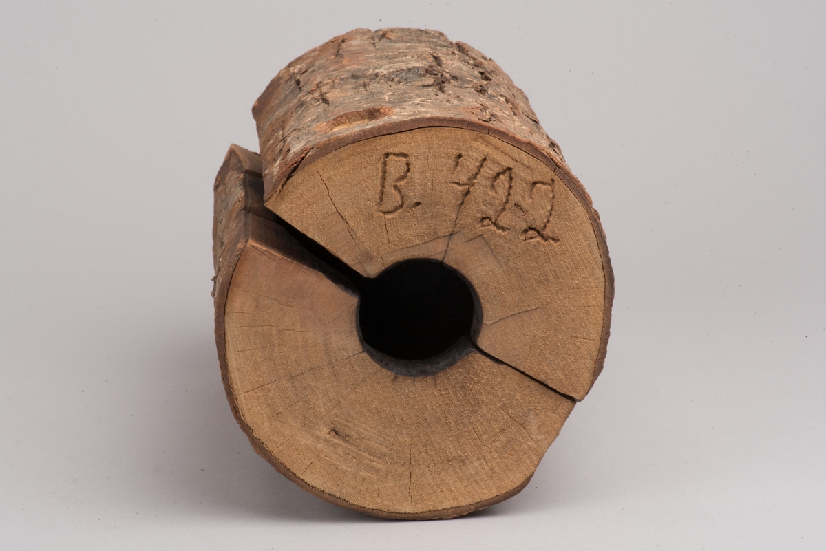 Påbörjad blåst glaskanna med träform.

Delbar form av trä som hålls ihop av märlor. På insidan utkarvad form för kanna. På utsidan två borrade hål, som inte är helt genomborrade, för redskapets grepp. På ovansidan öppning för glasmassan och inristat "B. 422". På undersidan tre inristade linjer.

Ämne till glaskanna, oval med avsmalnande hals och liten mynning. Drivet glas. Rundad botten. På sidan en klisteretikett.