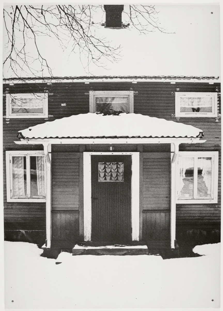 Ett äldre bostadshus med inbyggd veranda. 
Vinterbild.