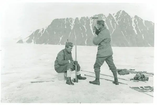Bildet viser Adolf Hoel som slår ned en teltstang på Liliehøkbreen i Kongsfjorden.