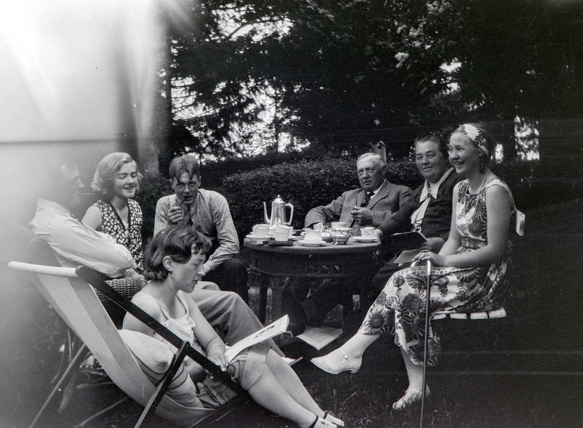 Ettermiddags kaffe i hagen på Nordre Ottestad. Til venstre: Valborg Taroline Alhaug, født Gjestvang (1904-1992), Andrea Margrethe Glærum, født Gjestvang (1924-1993). Odvar Kristen Gjestvang (1908-2002). Gulbrand Gjestvang (1874-1965). Ella Gjestvang, født Eli Cecilie Såstad (1881-1949). Eli Melbye, født Gjestvang (1911-2004). Tidspunkt ca 1935