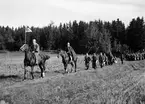 Uppträdande - två män till häst samt män med spjut i procession, Uppsala 1935