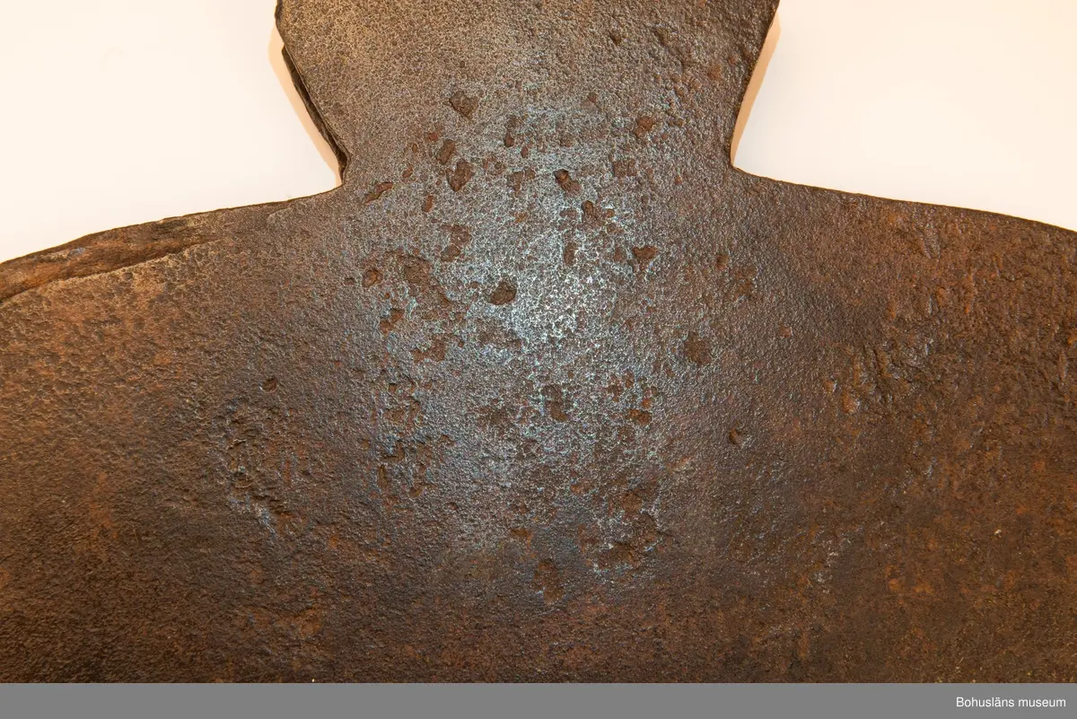 Handsmidd enkeleggad bred yxa med romboid holk med rektanguulärt uttag för skaft. Yxskaft saknas.
Viss gravrost.
Förvärvad 1952 från Johannes Olsson, Stillingön, Orust och då med uppgiften att yxan använts som bödelsyxa.

Svårbedömd tillverkningstid.

Ur handskrivna katalogen 1957-1958:
Bödelsyxa
L. 36,5. Br 24,5. Föremålet helt. Något rostat.