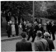 Tre plus två män promenerar med raska steg på Brahegatan i Gränna.
