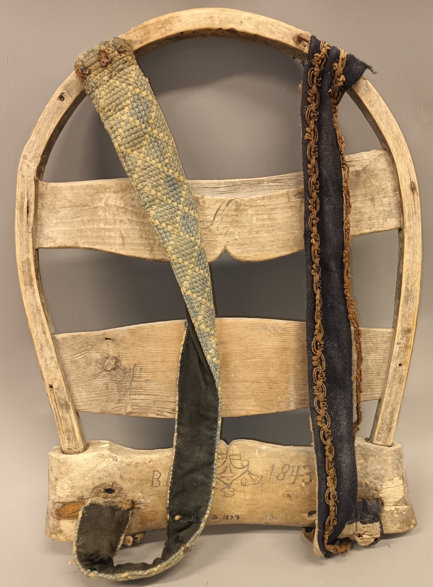 Bakmeis av ask med selar av tøy. Den eine selen er brodert med ullgarn. Den andre er i stoff med admiralband kring langsidene. Innskore bokstavar og årstal: B.I.S. 1813.