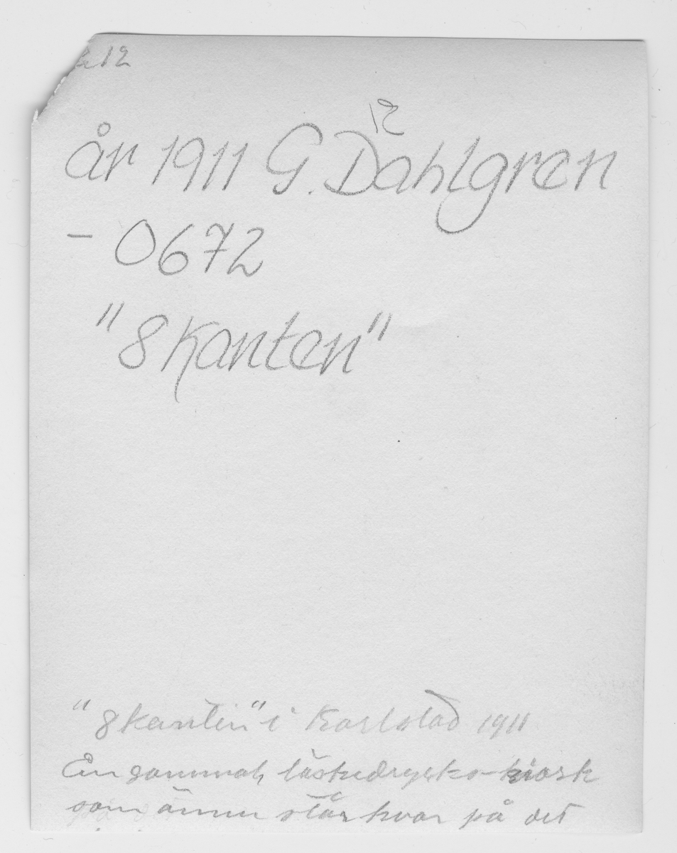 På kuvertet står följande information sammanställd vid museets första genomgång av materialet:  "Åttkanten" Herrhagen. En gammal läskedryckskiosk. 

Återstoden av värdshuset Åttkanten med sin ursprungliga placering norr om stickspåret till hamnen. Bilden togs 1911.