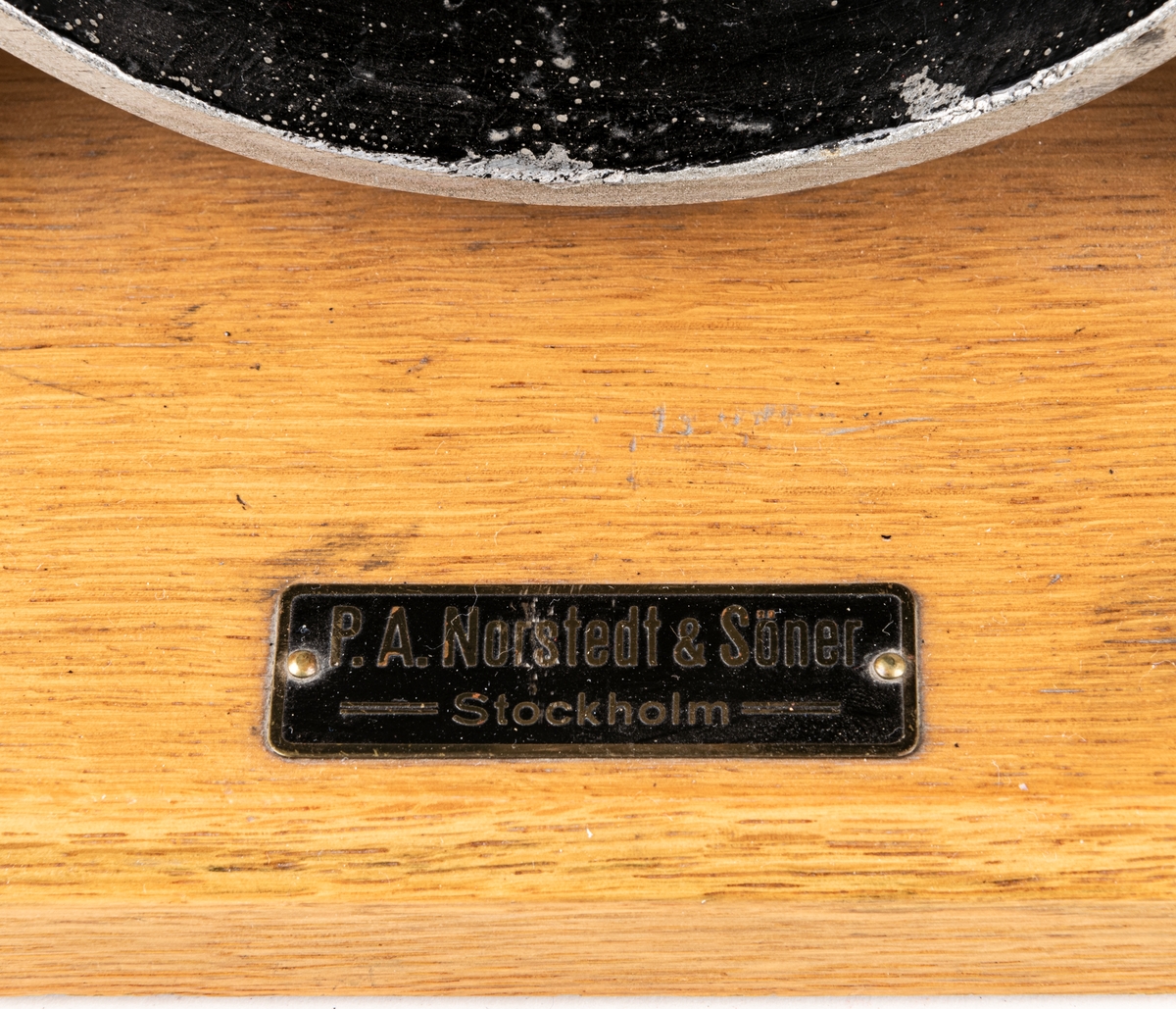 Modell av cylinder, vevstake och kolv i genomskärning. Järn, trä. Invändigt målad svart, röd och blå. Metalletikett med text "P.A. Norstedt & Söner Stockholm".