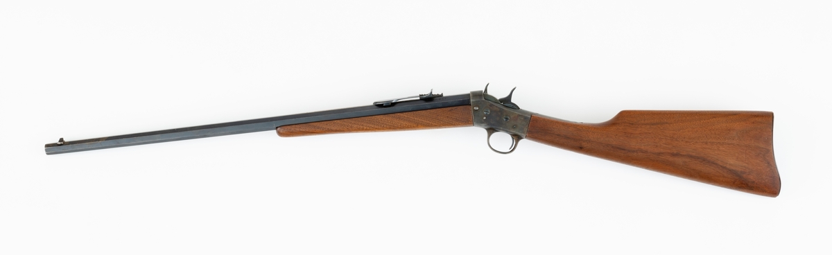 Tillegg innskrift: Remington TRADE MARK MODEL 4 25-10 R. F. Geværet har brunt, oljebehandlet treverk. Framstillingsnummeret er J 304870. Laget ca. 1870. Av størrelse kan geværet se ut som ei salongrifle, men kaliberet, 25-10, er litt større enn på Krag. R. F. står for Rand Fire (randtenning. ) 10-tallet står for 10 gram svartkrutt. Dvs. ca. 4 gram. Dette er en meget kraftig ladning, nesten like mye som på den store Remington. Det må være en av de raskeste svartkruttpatroner som er laget.