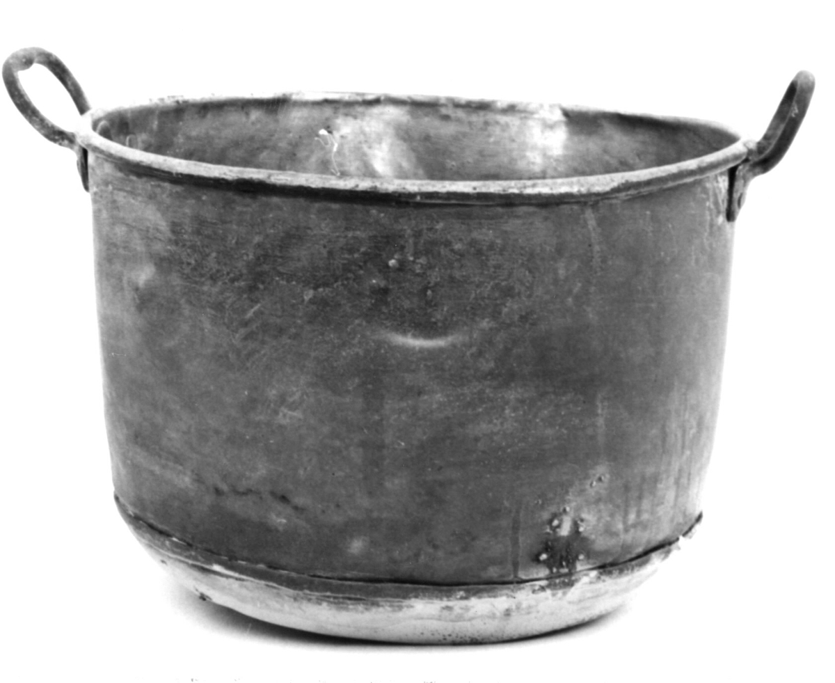 Kittel av koppar. Saknar lock. Två nitade ovala handtag. Skråkantad nedtill. Storaxel 34 cm. Lillaxel 24 cm.
