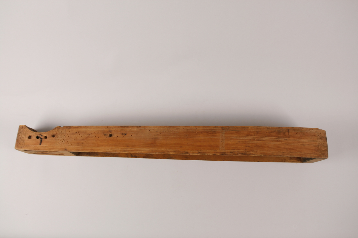 Dobble kantstreker (utskåret i ulike teknikker). 
Sidedekor med doble kantstreker (utskåret i ulike teknikker).  4 felt med bånddekor, 3 dobbel, 1 enkel sikksakkdekor. 
Sikksakkkdekor på skruekassen, to midtstilte doble strekdekorer på nedre delen av sidene. 
Endestykke med skåret, enkel strekdekor på de 2 midtdelene. 
Dobbel strekdekor på den ene ytterdelen, utslitt på den andre (derfor usikker).