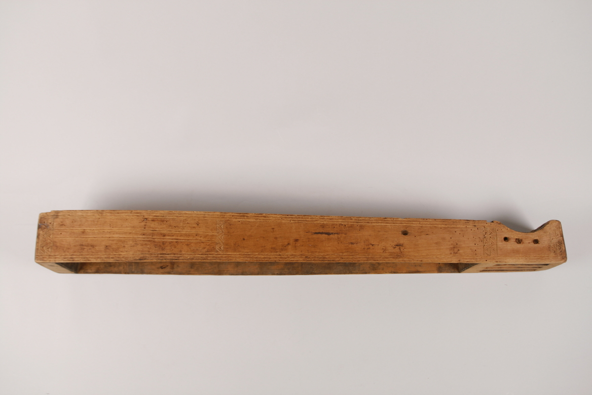 Dobble kantstreker (utskåret i ulike teknikker). 
Sidedekor med doble kantstreker (utskåret i ulike teknikker).  4 felt med bånddekor, 3 dobbel, 1 enkel sikksakkdekor. 
Sikksakkkdekor på skruekassen, to midtstilte doble strekdekorer på nedre delen av sidene. 
Endestykke med skåret, enkel strekdekor på de 2 midtdelene. 
Dobbel strekdekor på den ene ytterdelen, utslitt på den andre (derfor usikker).