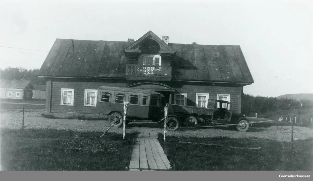 Hus som tilhører klosteret med en buss og lastebil parkert utenfor i Petsamo i daværende Finland.
Usikkert når bildet er tatt, men sannsynligvis i perioden 1920 - 1944.